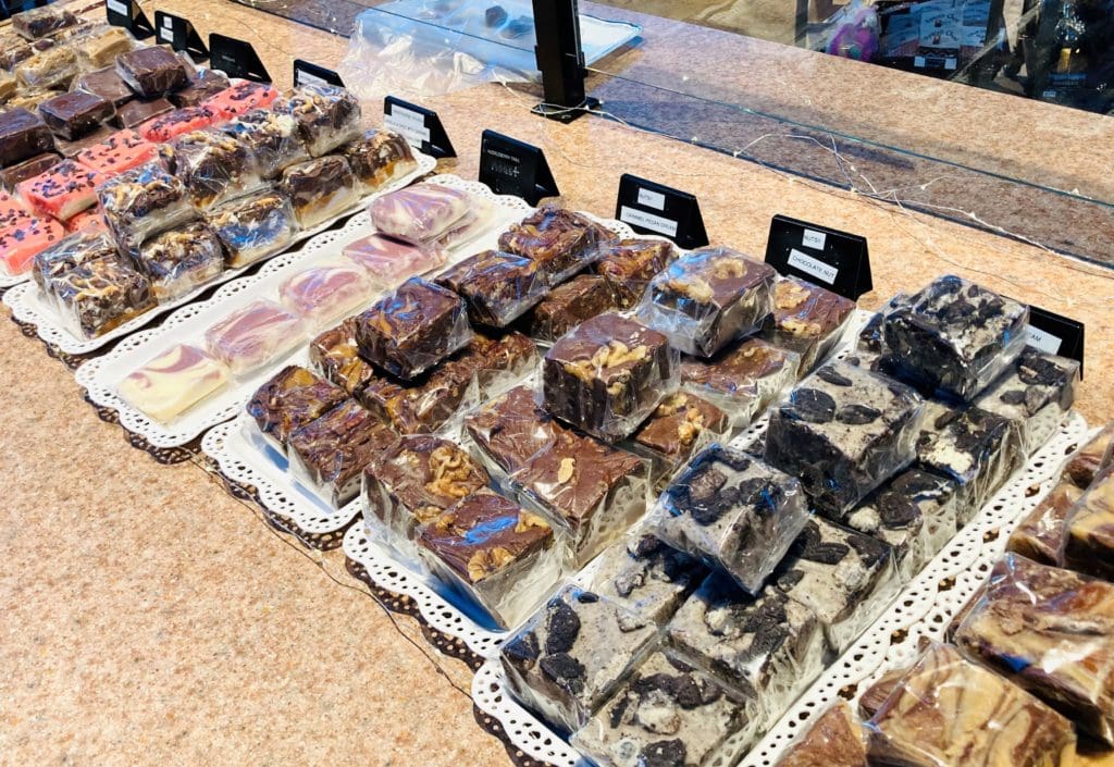 Groups of assorted fudge with cookies and other toppings inside of them laid out on a granite counter